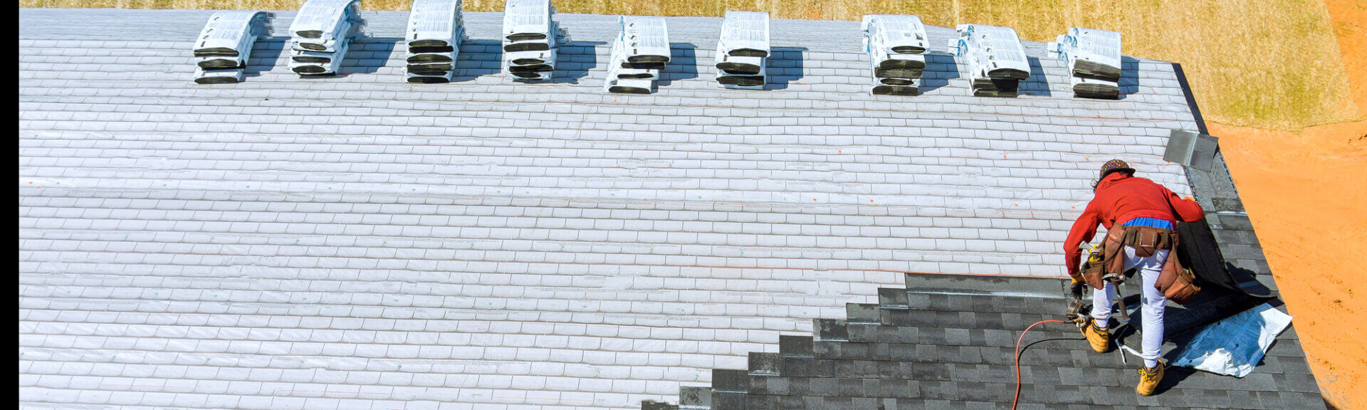 Worker Hands Installing Bitumen Roof Shingles With Air Hammer And Nail